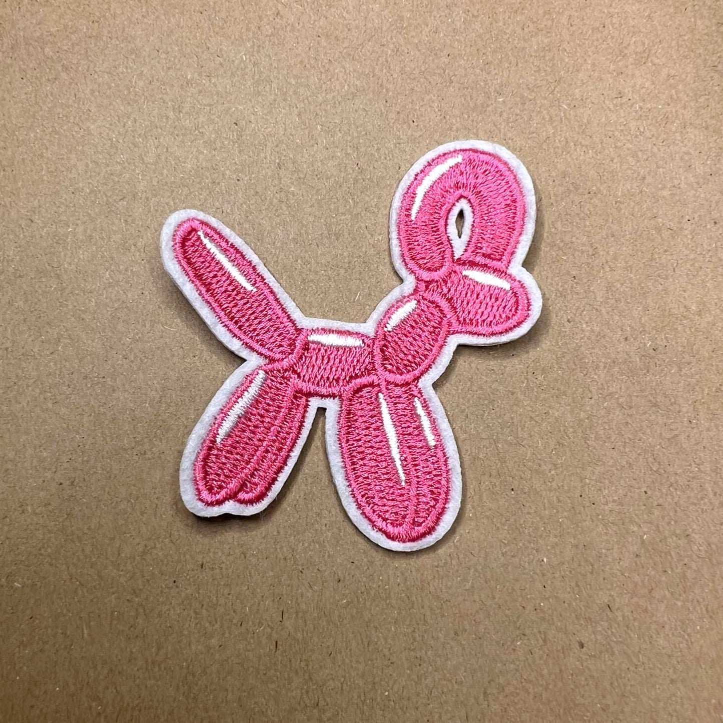 Brodert strykemerke av rosa ballongdyr