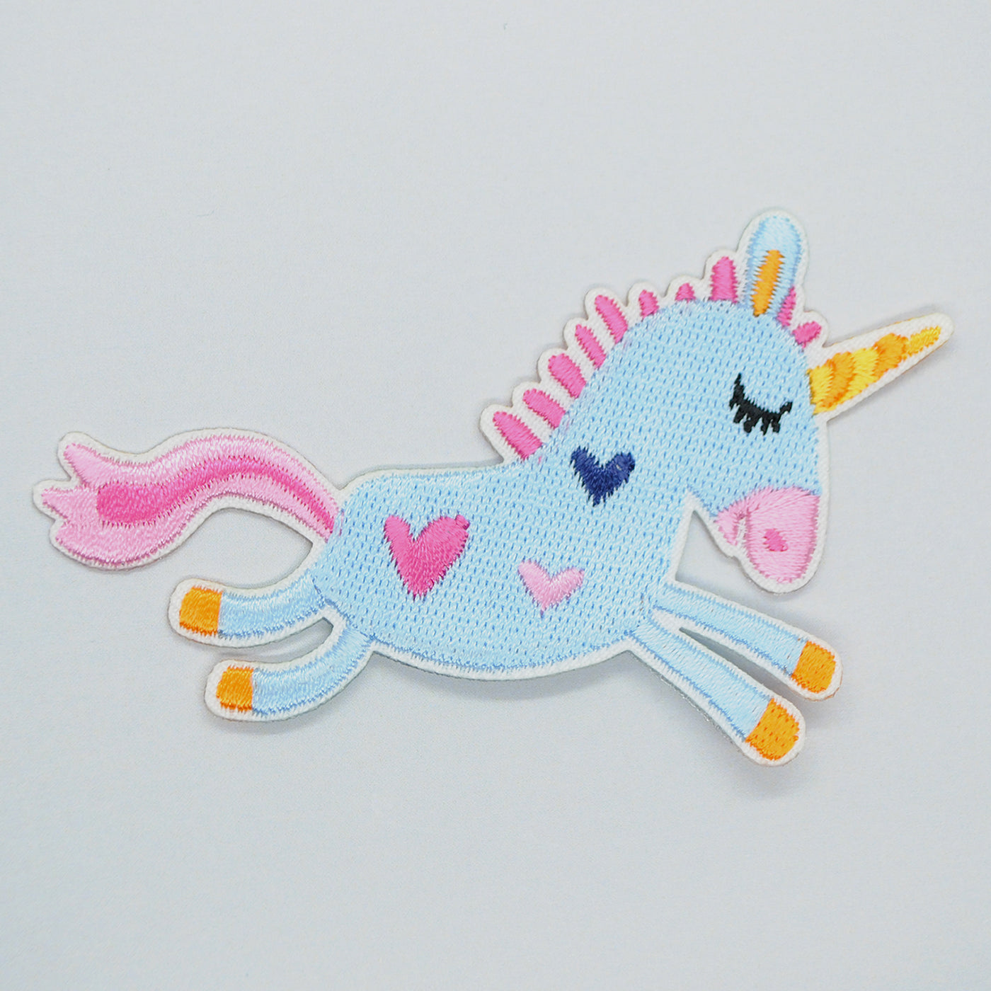 Brodert strykemerke av blå enhjørning med hjerter