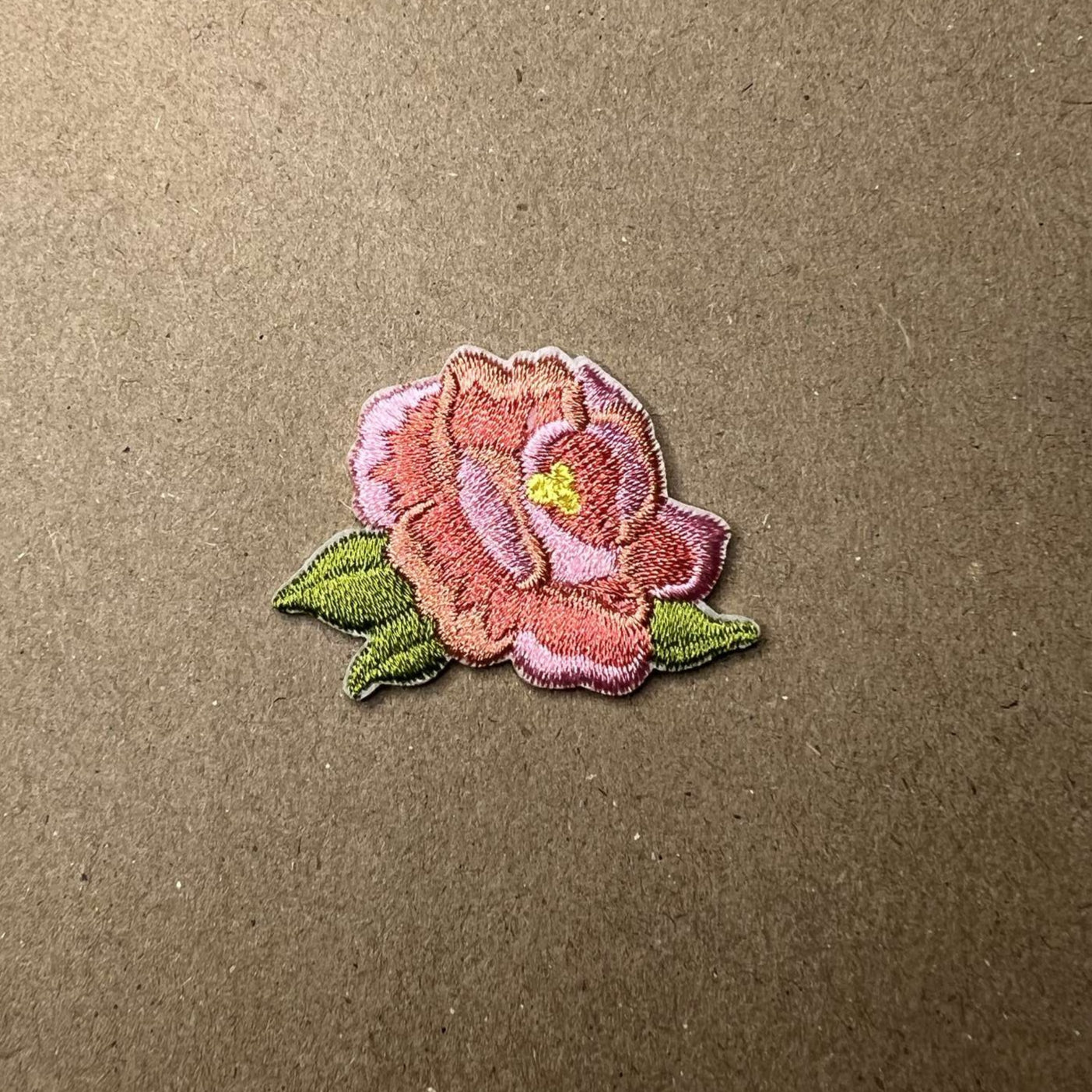 Brodert strykemerke av liten søt rosa blomst