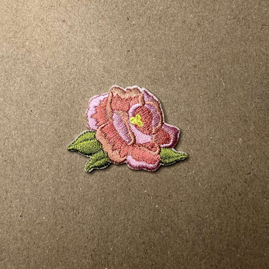 Brodert strykemerke av liten søt rosa blomst