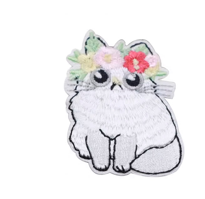 Brodert strykemerke av hvit katt med blomsterkrans