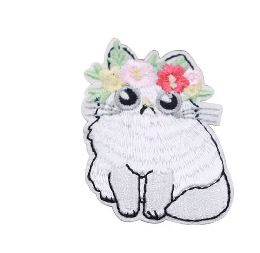 Brodert strykemerke av hvit katt med blomsterkrans