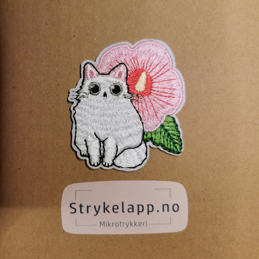 Brodert strykemerke av hvit katt med blomst
