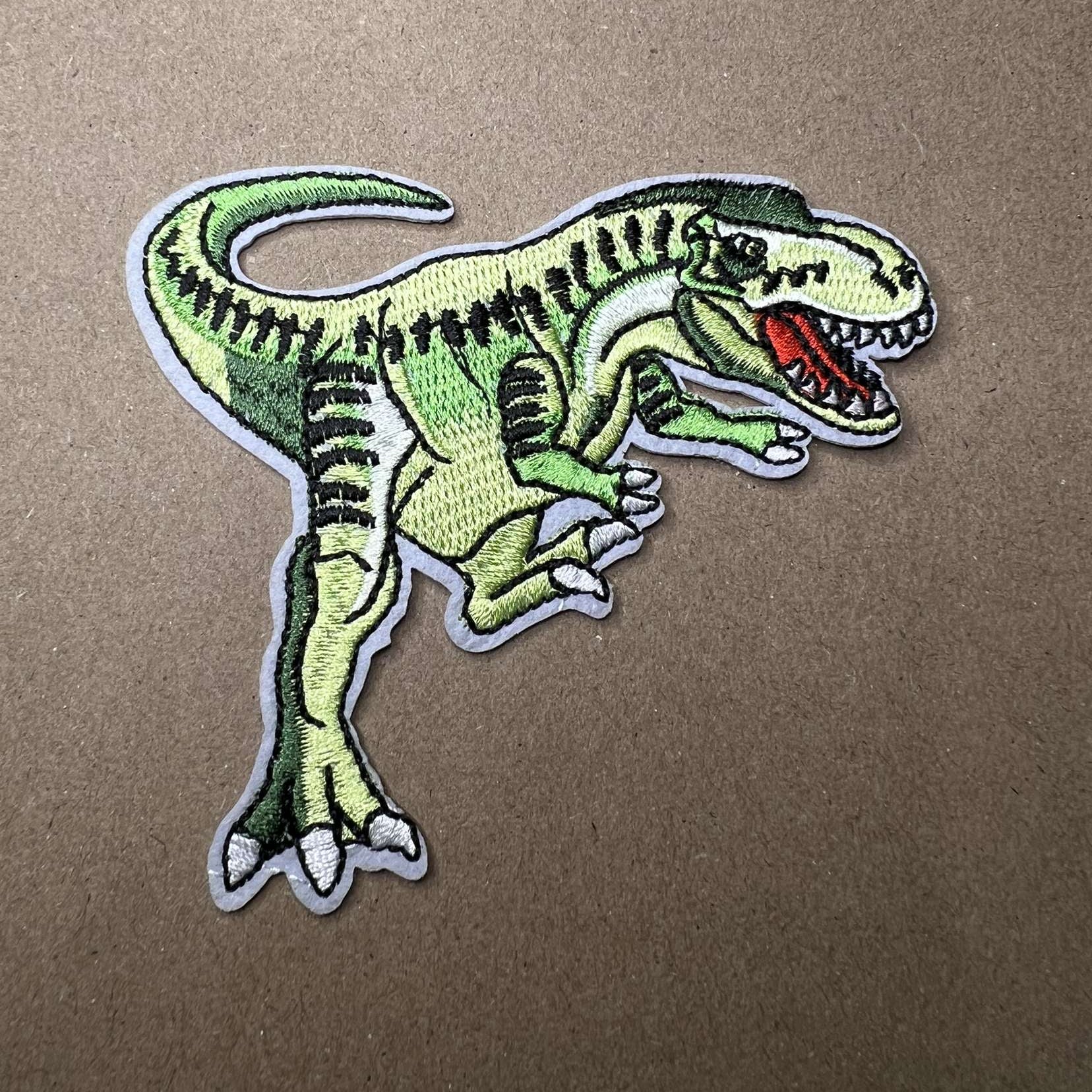 Strykelapp med motiv av grønn T-Rex 