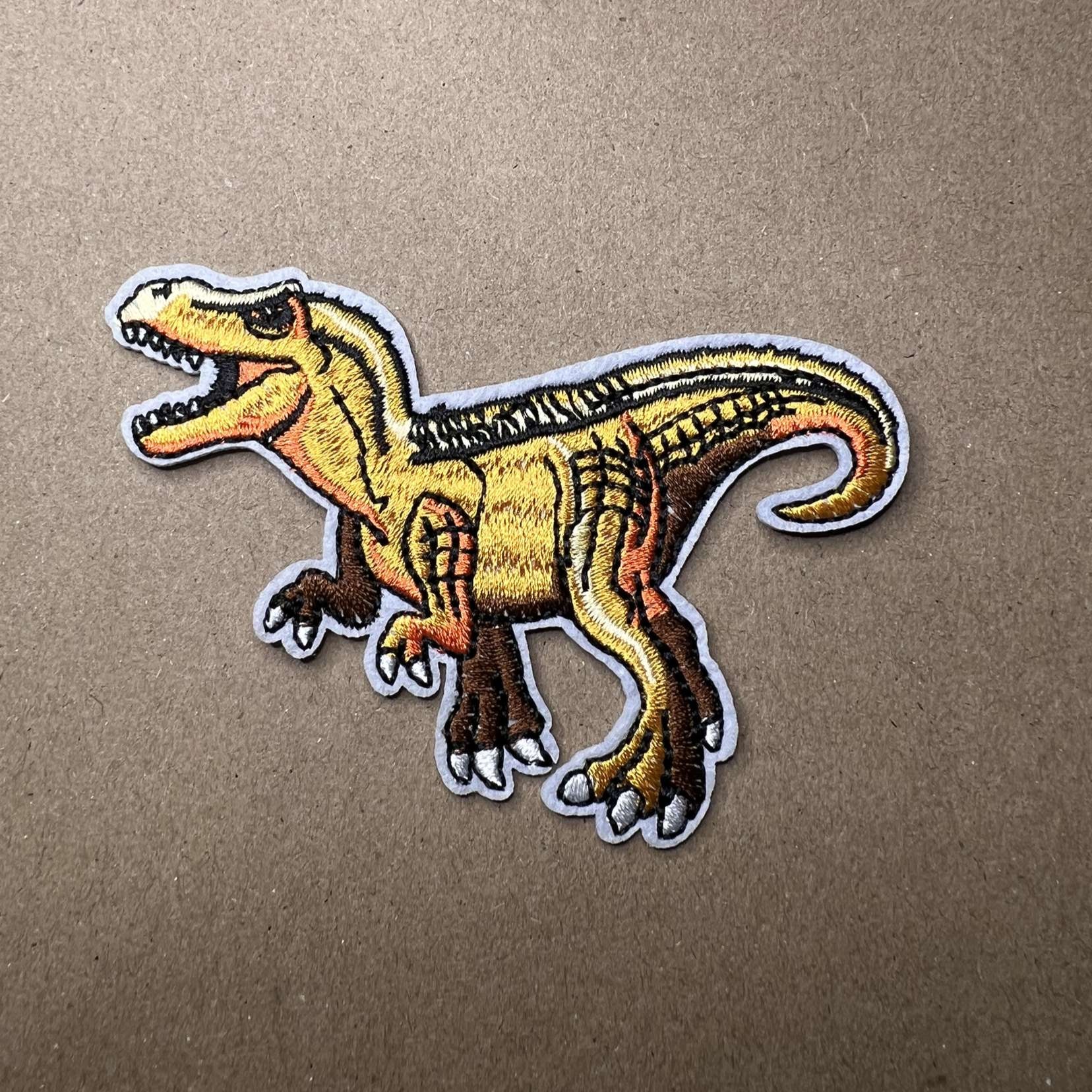 Strykelapp med motiv av gul T-Rex dinosaur