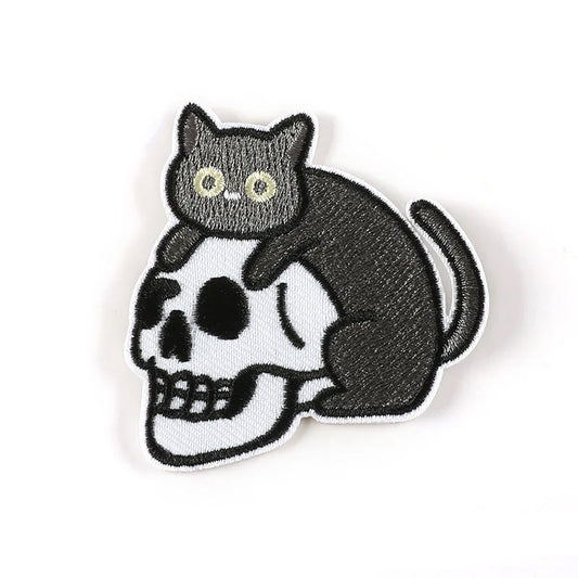 Brodert strykemerke av katt som ligger oppå en hodeskalle