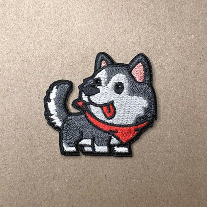 Brodert strykemerke av grå og hvit hund med rødt skjerf