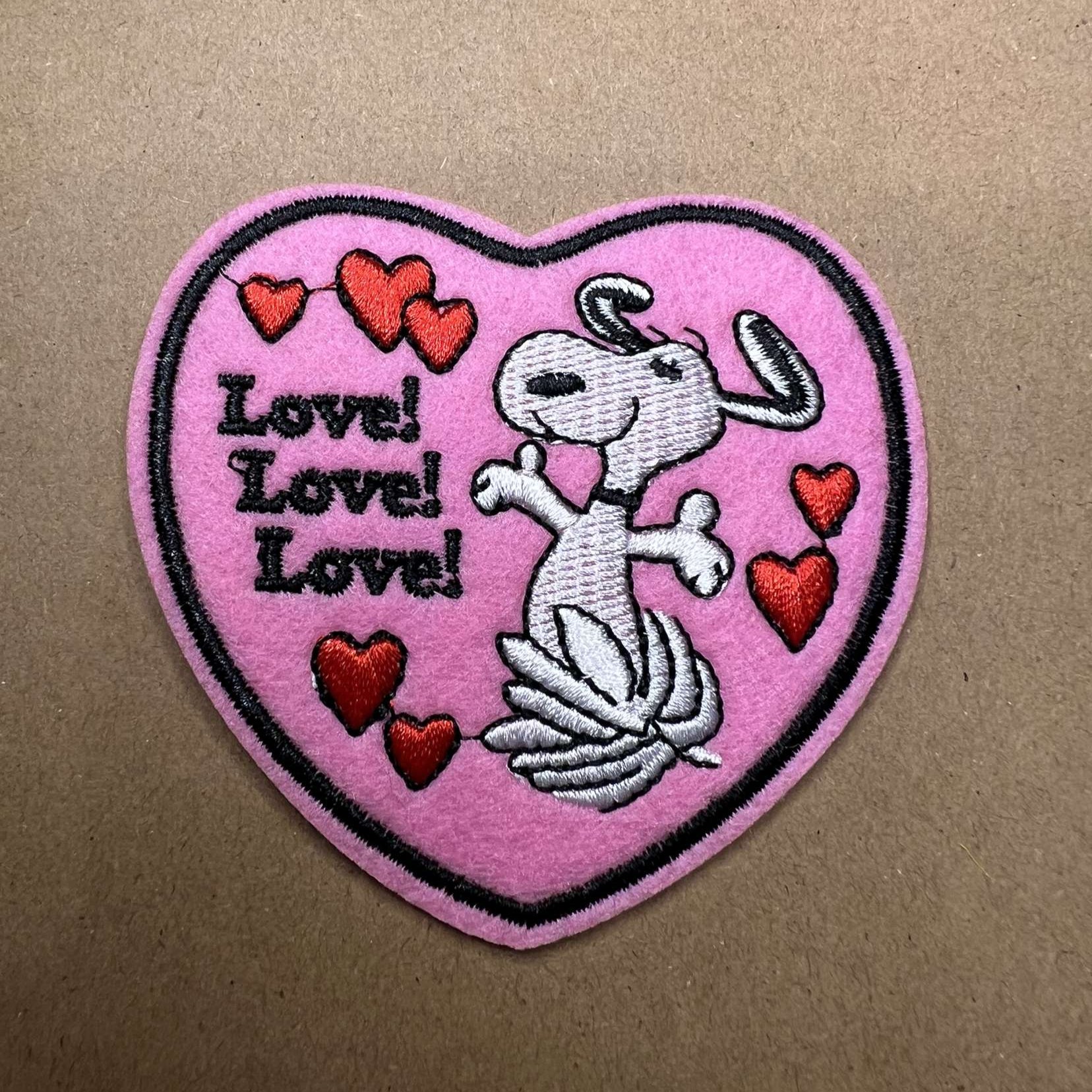 Brodert strykemerke av Snoopy i rosa hjerte