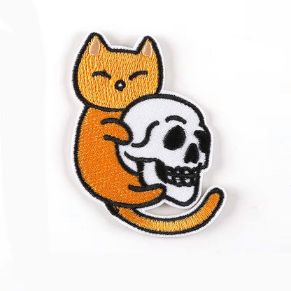 Brodert strykemerke av en orange katt som holder en hodeskalle