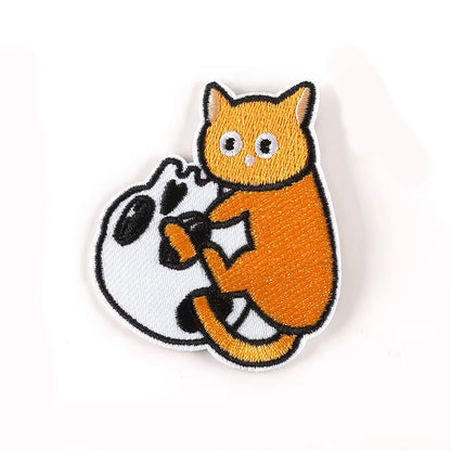 Brodert strykelapp av orange katt som leker med en hodeskalle