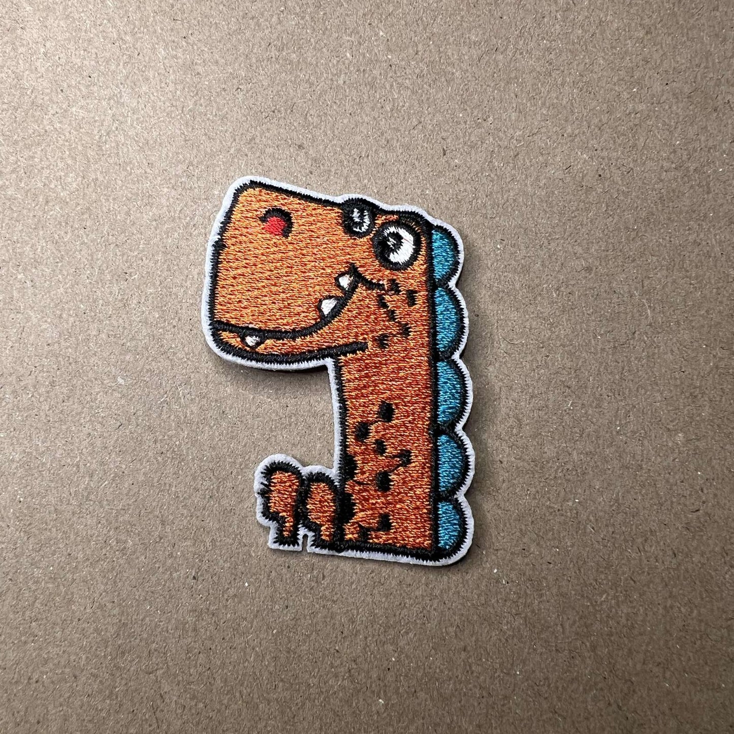 Strykelapp med motiv av Orange og blå Dino