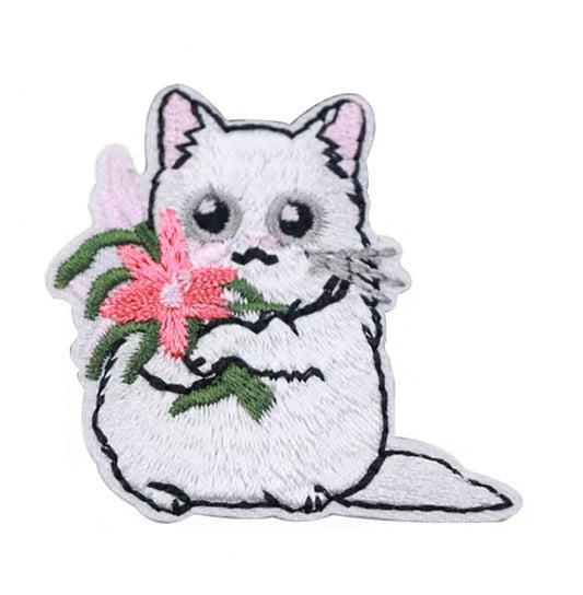 Brodert strykemerke av hvit katt med blomsterbukett