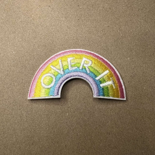 Brodert strykemerke med regnbue med skriften "Over It"