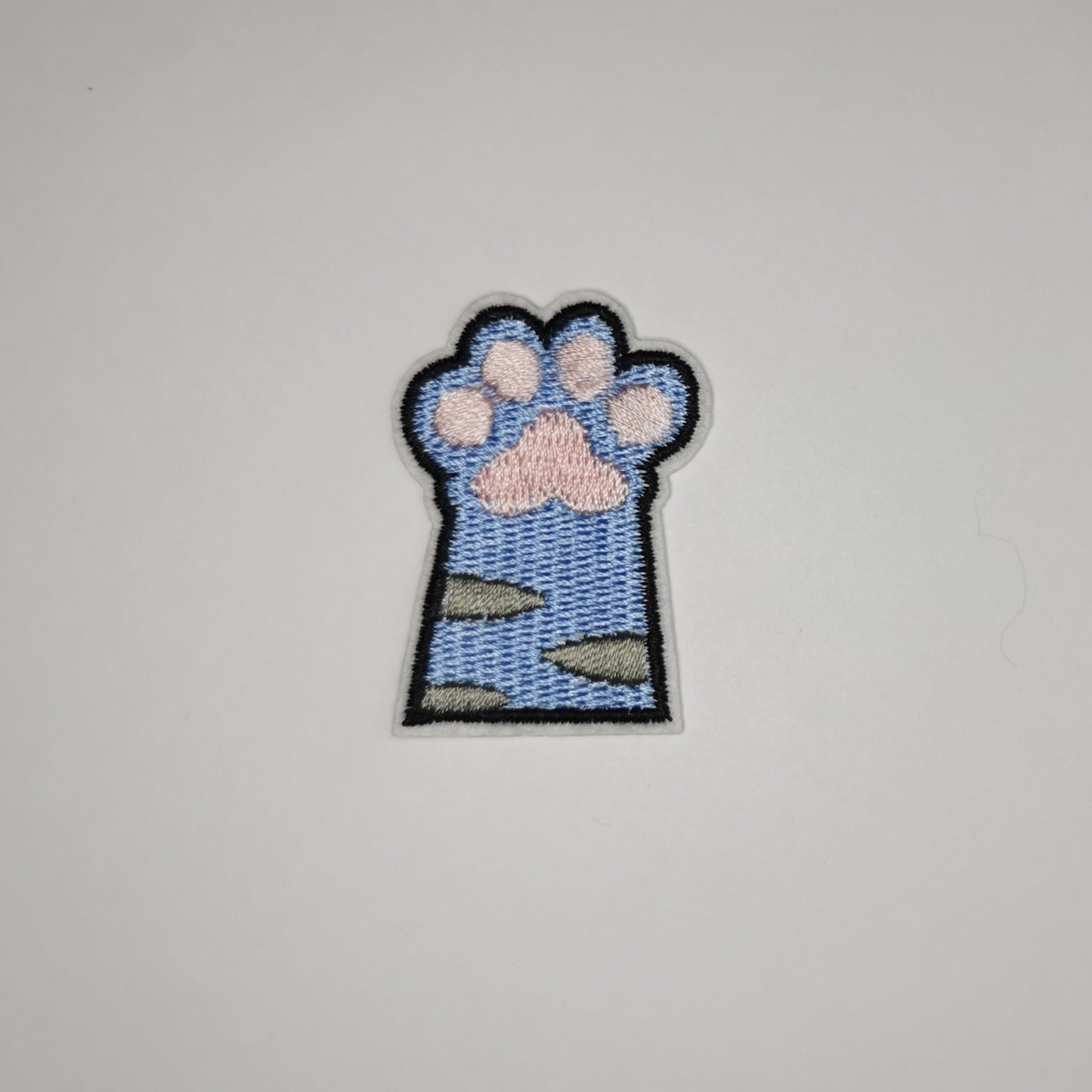 Brodert strykemerke av kattepote, blå med grå striper