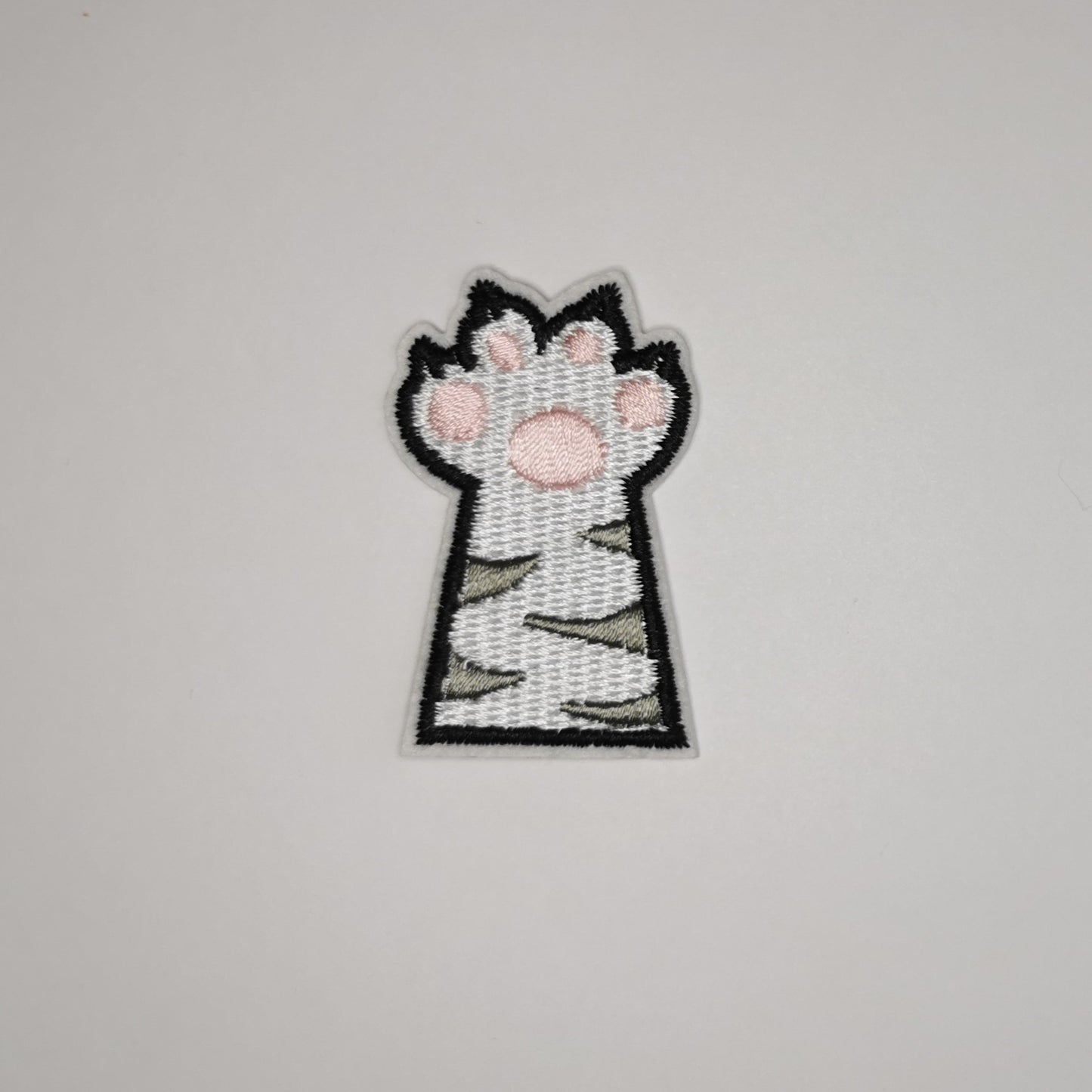 Brodert strykemerke av kattepote, hvit med grå striper