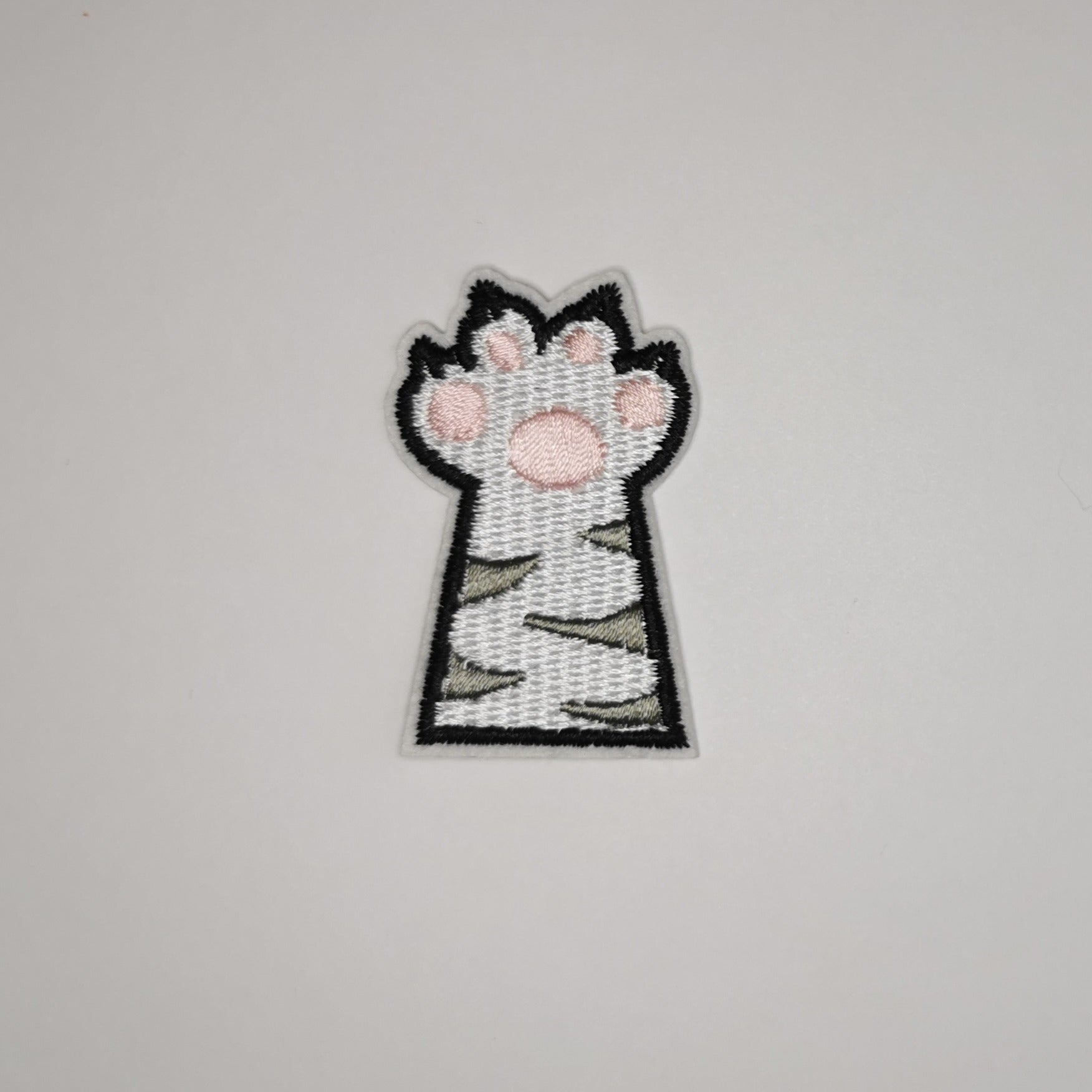 Brodert strykemerke av kattepote, hvit med grå striper