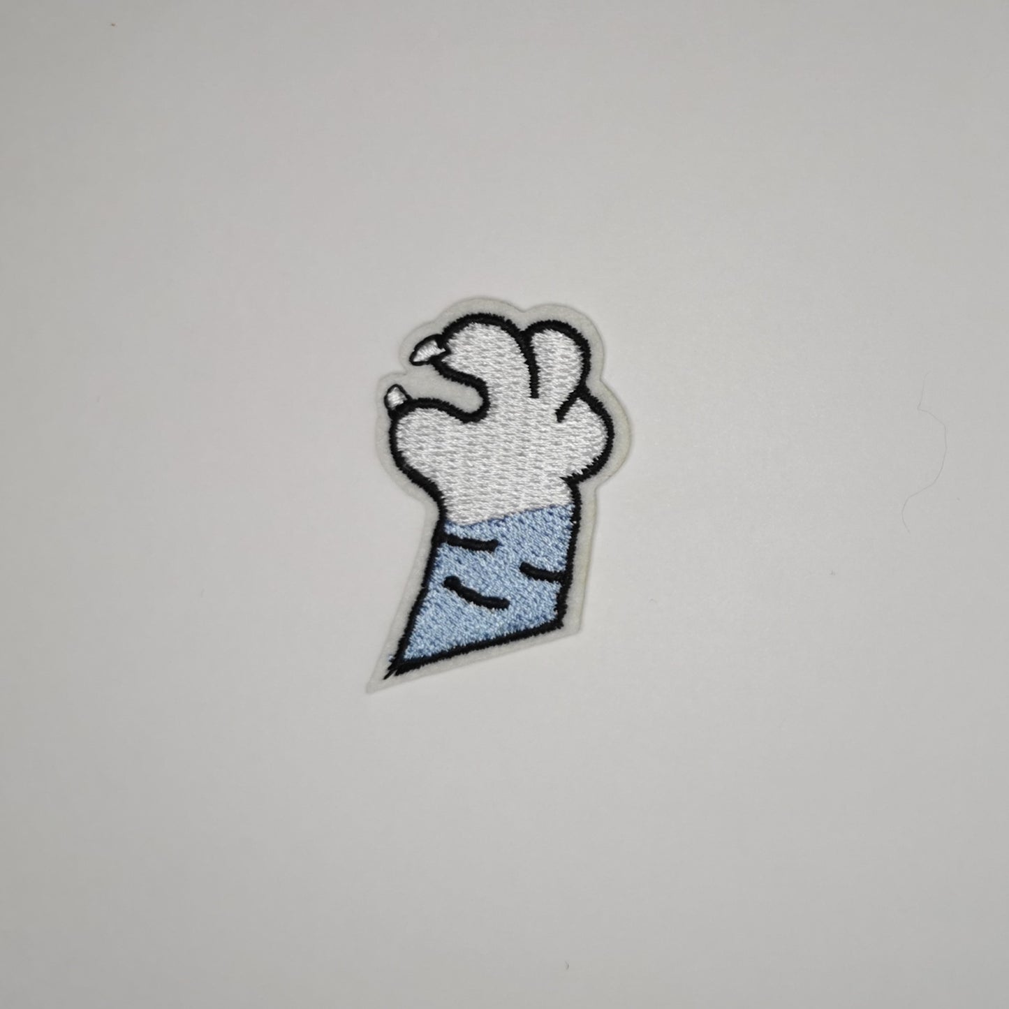 Brodert strykemerke av kattepote, hvit og blå