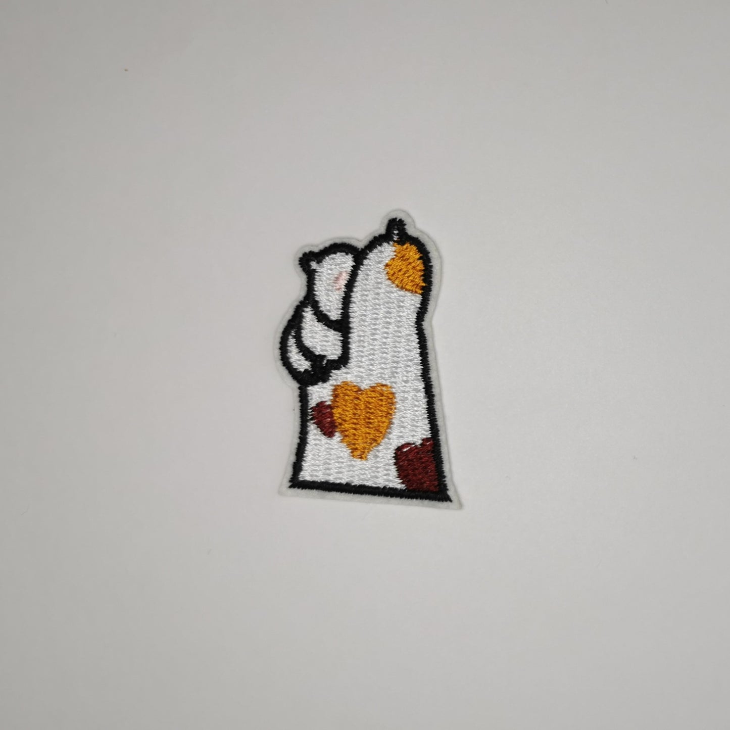 Brodert strykemerke av kattepote, hvit med brunt hjerte