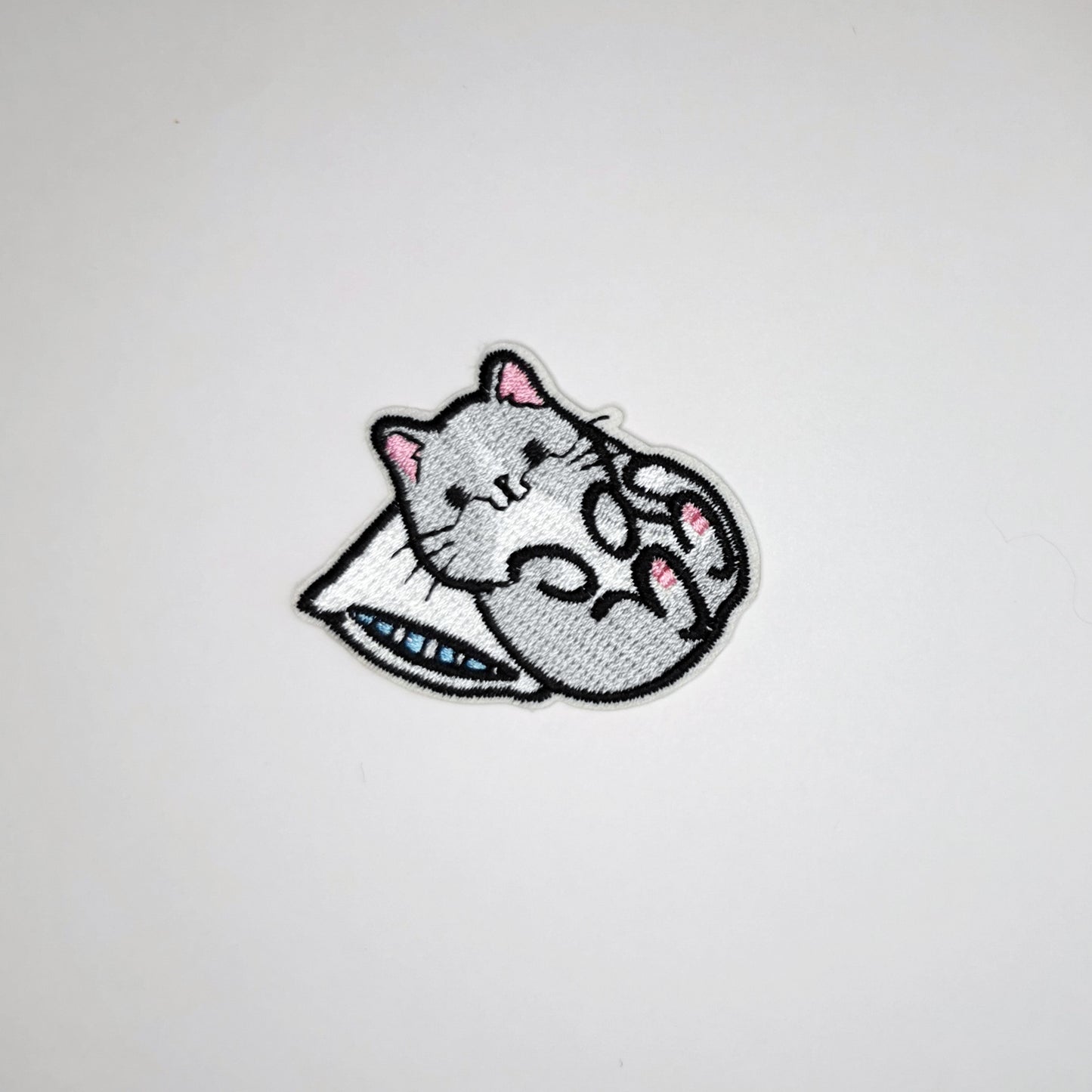 Brodert strykemerke av katt som ligger med hodet på pute