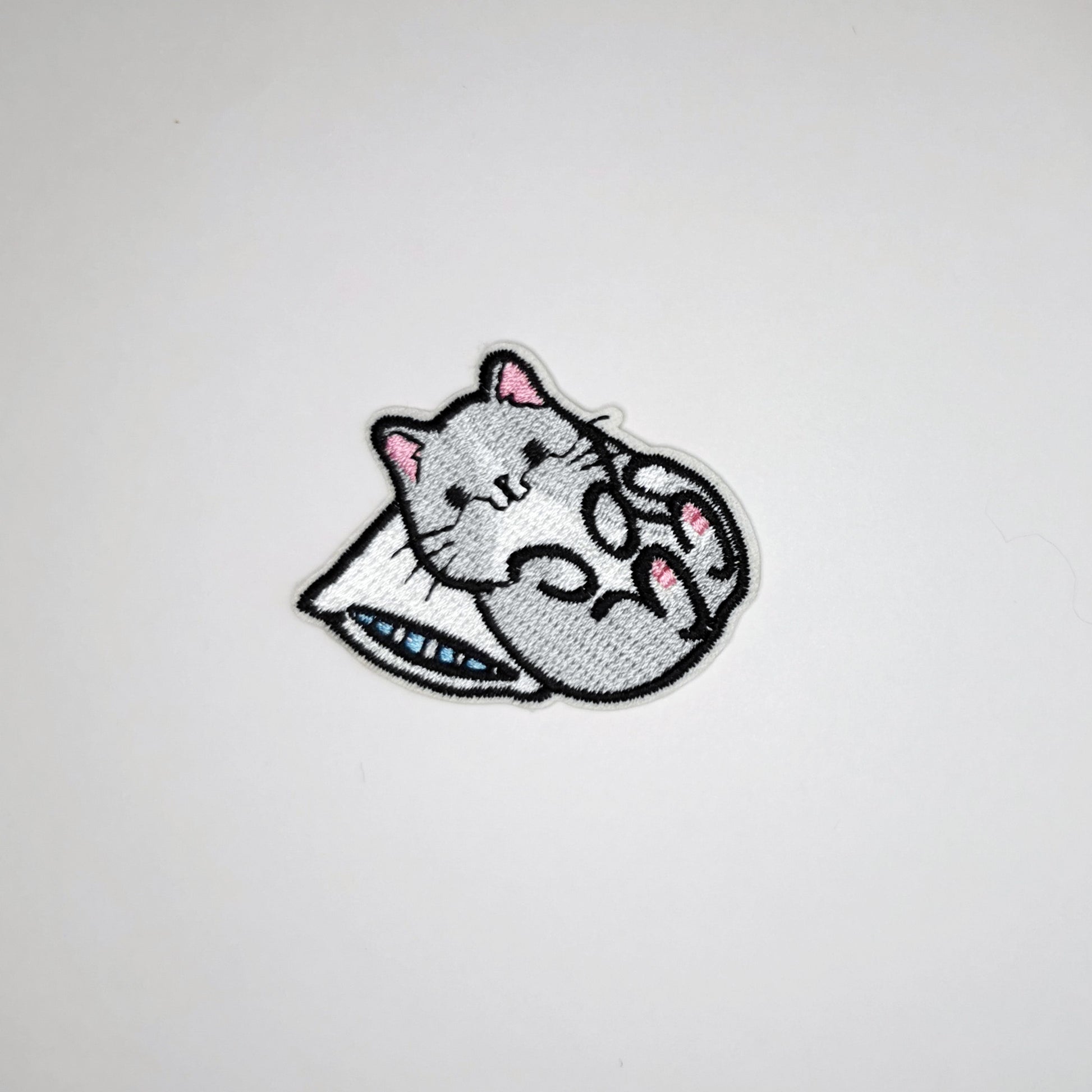 Brodert strykemerke av katt som ligger med hodet på pute