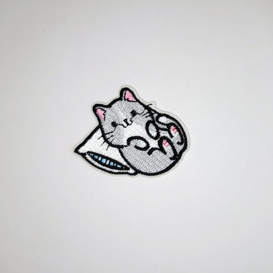 Brodert strykemerke av katt som ligger med hodet på pute