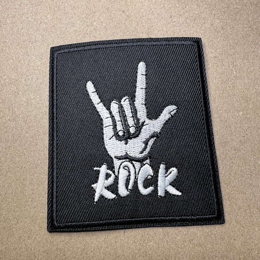 Brodert strykemerke av hånd som viser "Rock"-tegn med teksten "Rock"