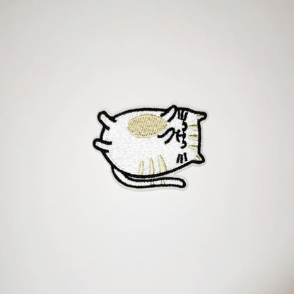 Brodert strykemerke med katt som ligger på ryggen