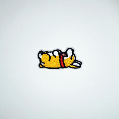 Brodert strykemerke med sovende hundsom ligger på rygg