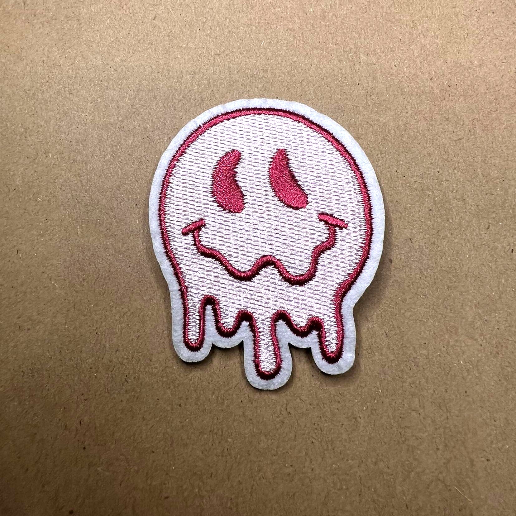 Brodert strykemerke av en rosa smeltende smiley