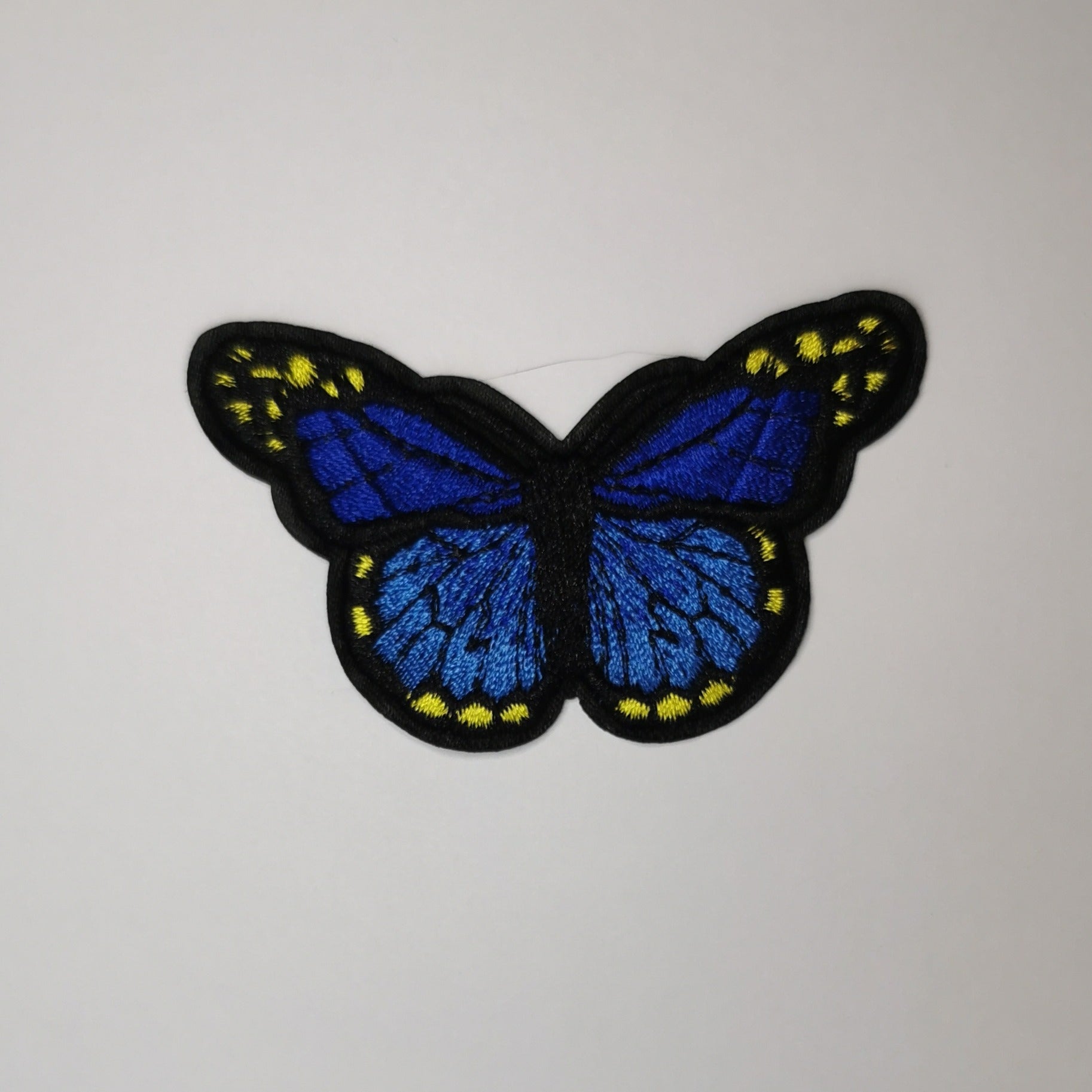 Brodert strykemerke, marineblå, blå og gul sommerfugl