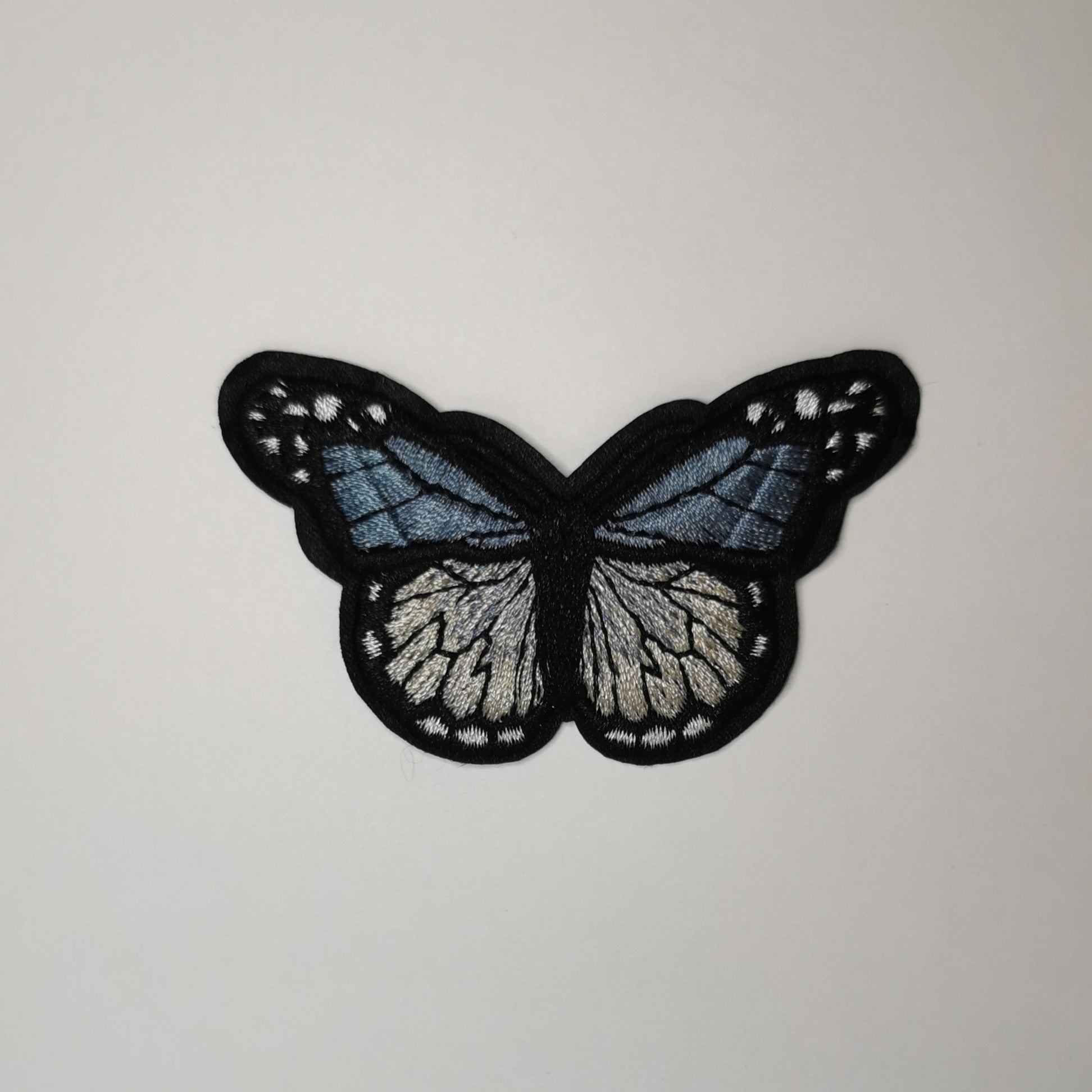 Brodert strykemerke, blå sommerfugl