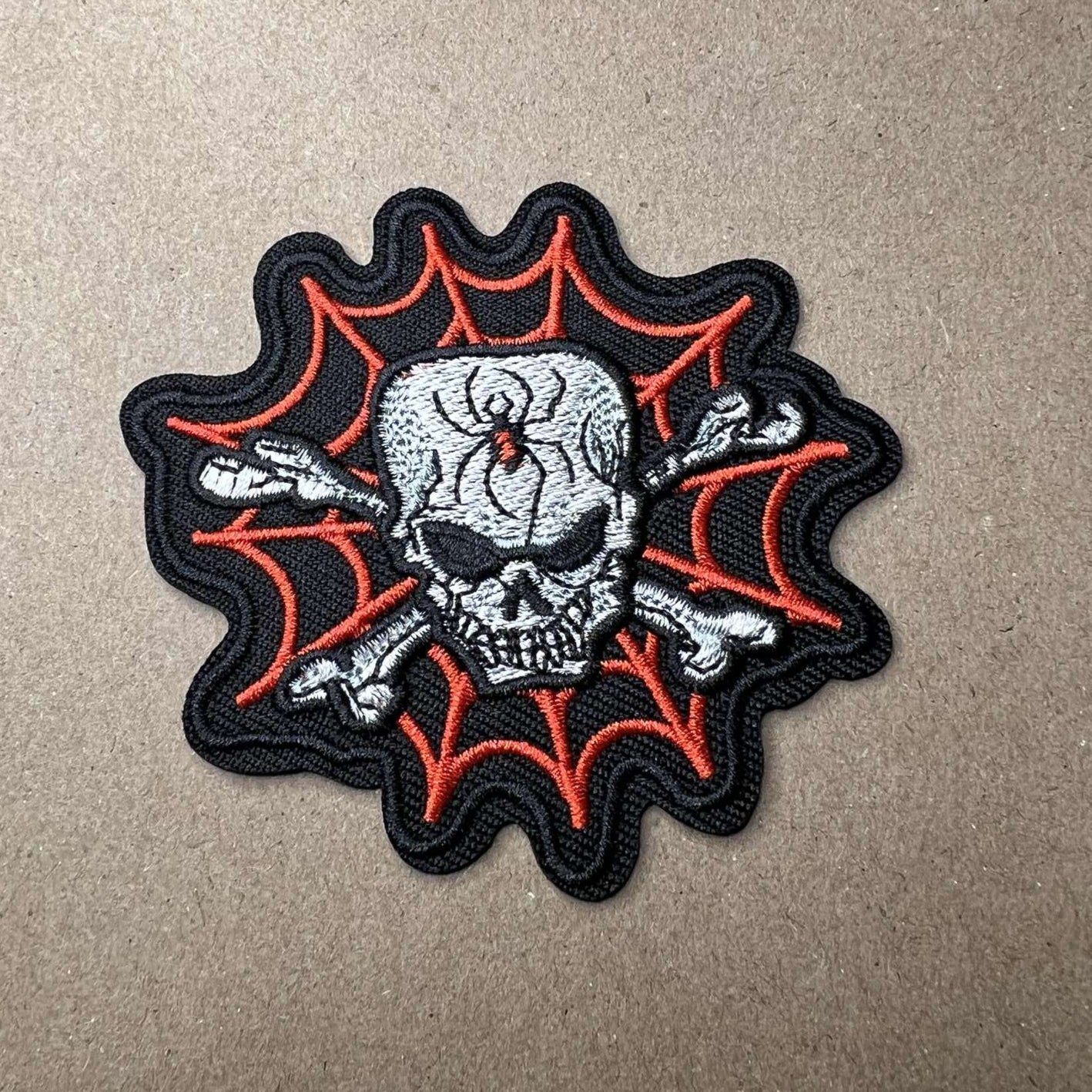 Brodert strykemerke av hodeskalle i spindelvev