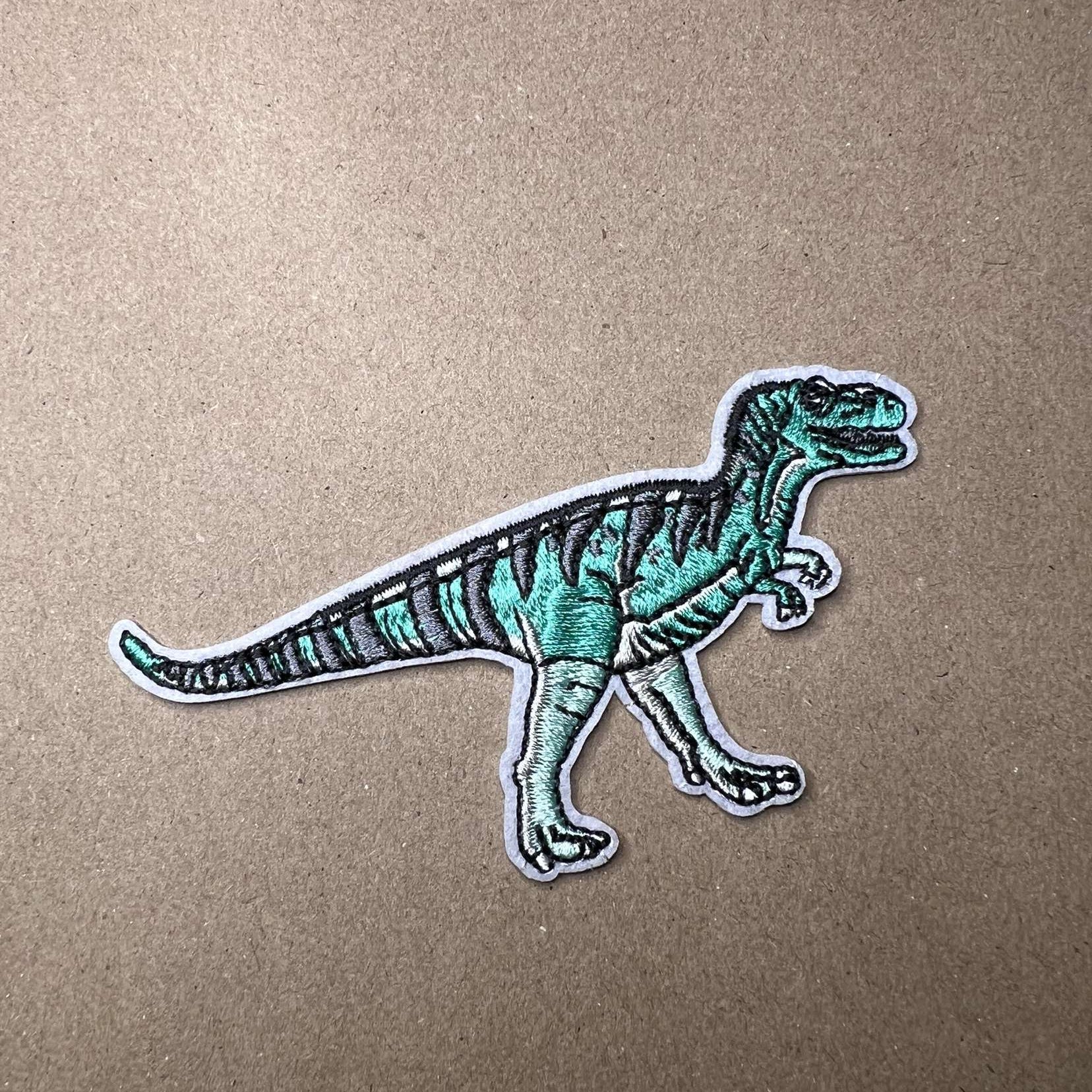 Strykelapp med motiv av turkis T-Rex