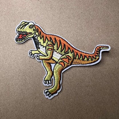 Strykelapp med motiv av velociraptor dinosaur
