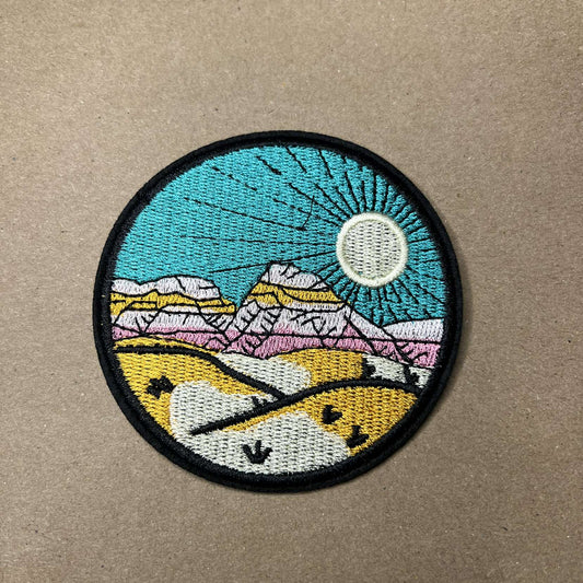 Brodert strykemerke av fjell i solnedgang